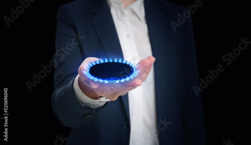 Closeup view of woman holding gas burner with blue flame on black background