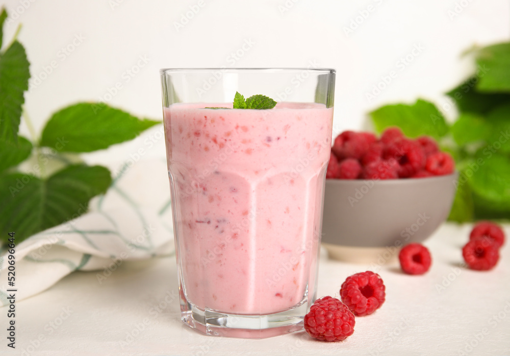 Glass of tasty raspberry smoothie on white table Glass of tasty raspberry smoothie on white table