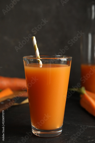 Glass of freshly made carrot juice on black table