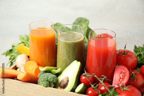 Delicious vegetable juices and fresh ingredients on light background © New Africa