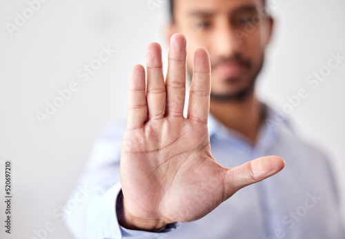 Photography Closeup of the hand of a business man showing stop, saying no or not accepting a deal in an office at work
