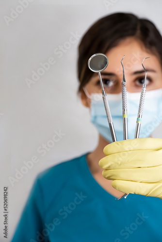 young female dentist holding dental instruments in her hand