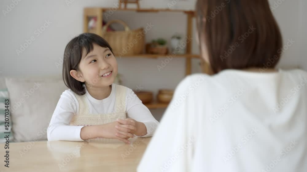 リビングで会話をする女の子とお母さん リビングで会話をする女の子とお母さん