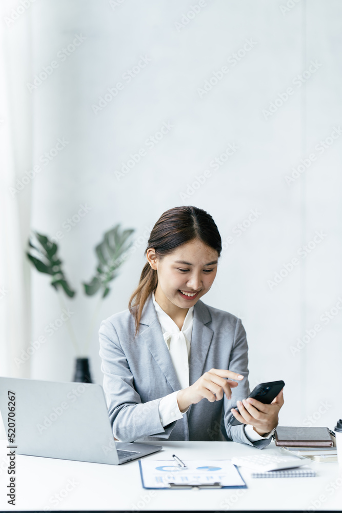 Asian businesswoman in formal suit in office happy and cheerful during using smartphone and working. Asian businesswoman in formal suit in office happy and cheerful during using smartphone and working.