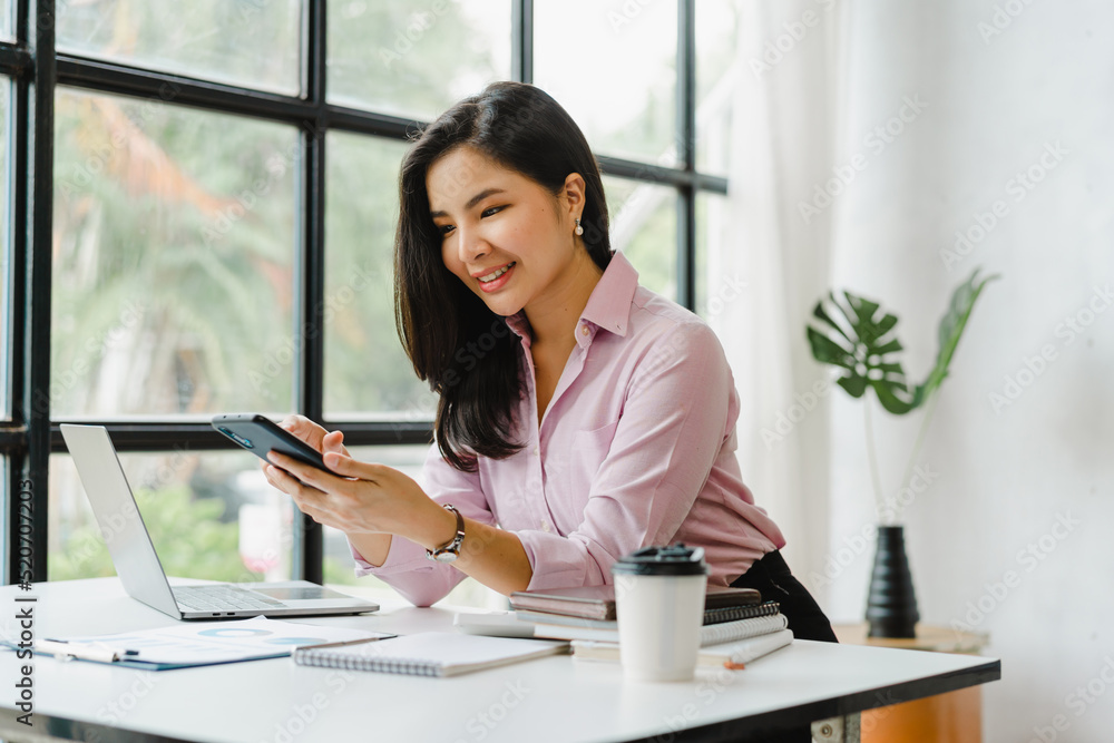 Young beautiful charming asian businesswoman using mobile smart phone in the office. Young beautiful charming asian businesswoman using mobile smart phone in the office.