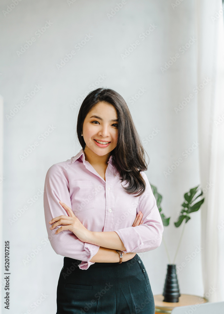 Young Pretty Asian business female person looking to camera while working in the office.