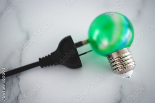 clean green energy  electric plug next to green lightbulb