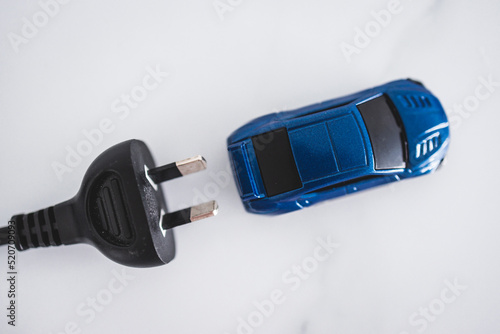 electric or hybrid vehicles, blue toy car with plug behing it photo