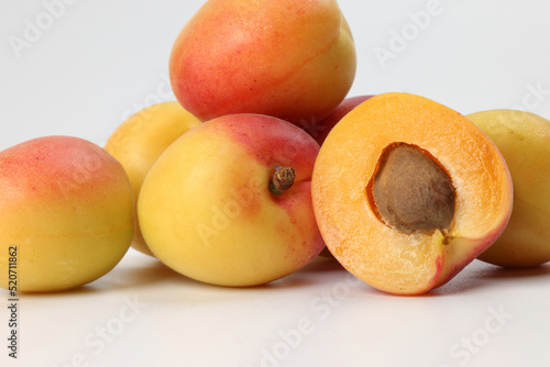 Fresh ripe juicy yellow orange red apricot fruit pile whole cut half slice seed on white background