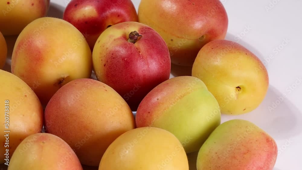 Fresh ripe juicy yellow orange red apricot fruit pile whole cut half slice seed on white background turn rotate move Fresh ripe juicy yellow orange red apricot fruit pile whole cut half slice seed on white background turn rotate move