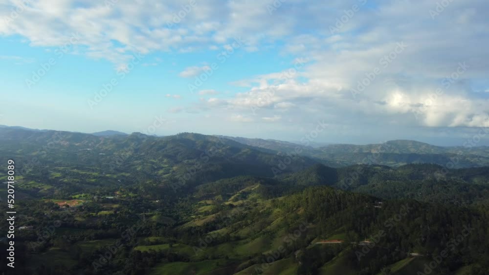 Aerial over mountain range covered with dense green forest near Jarabacoa, Dominican Republic. Beautiful scenery on a bright sunny day Aerial over mountain range covered with dense green forest near Jarabacoa, Dominican Republic. Beautiful scenery on a bright sunny day
