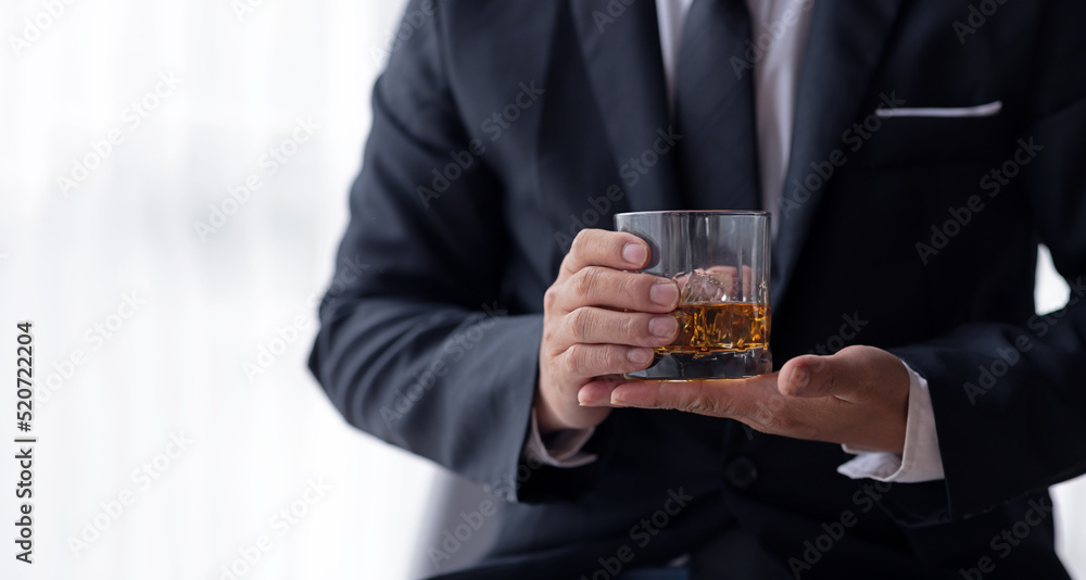 Businessman hand holding a glass of whiskey white background