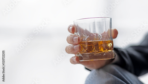 Businessman hand holding a glass of whiskey white background
