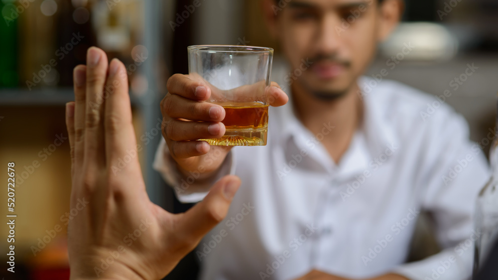 Asian man refusing alcohol from friend or another person because he want to quit drinking or will drive a vehicle. Asian man refusing alcohol from friend or another person because he want to quit drinking or will drive a vehicle.