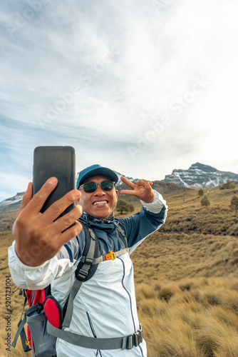 Happy latin man hiker taking a selfie on mountain edge in mexico © @Nailotl