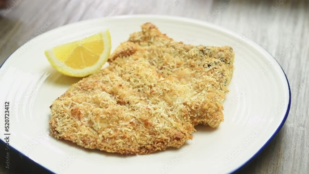 Serving pork chop milanese on the table.
Serving pork chop milanese on the table.