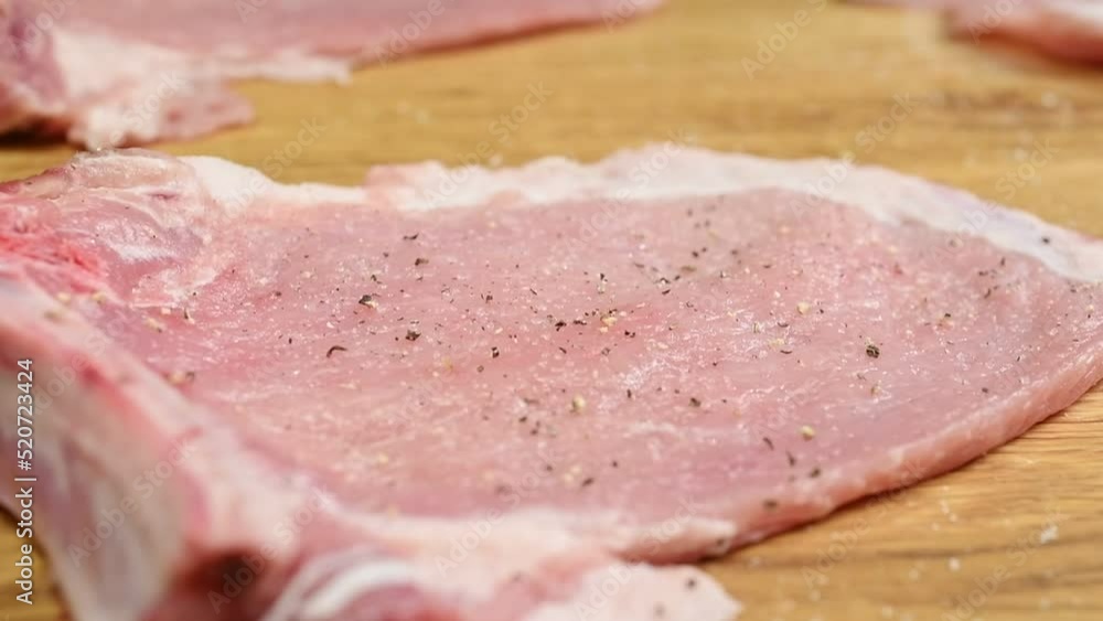 Sprinkling black pepper on a raw pork chop.
Sprinkling black pepper on a raw pork chop.