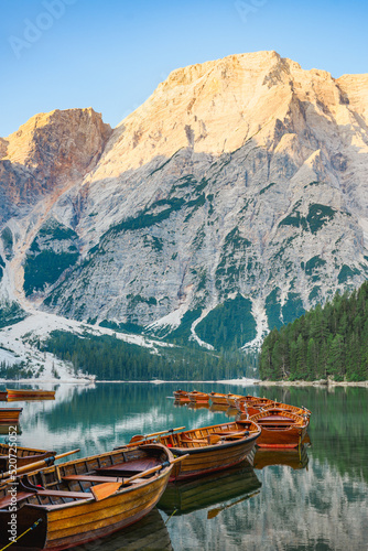 Obraz na płótnie (Selective focus) Stunning view of the Lake Braies (Lago di Braies) with some wooden boats and beautiful mountains reflected in the water. Lago di Braies is an alpine lake in the Dolomites, Italy w salonie