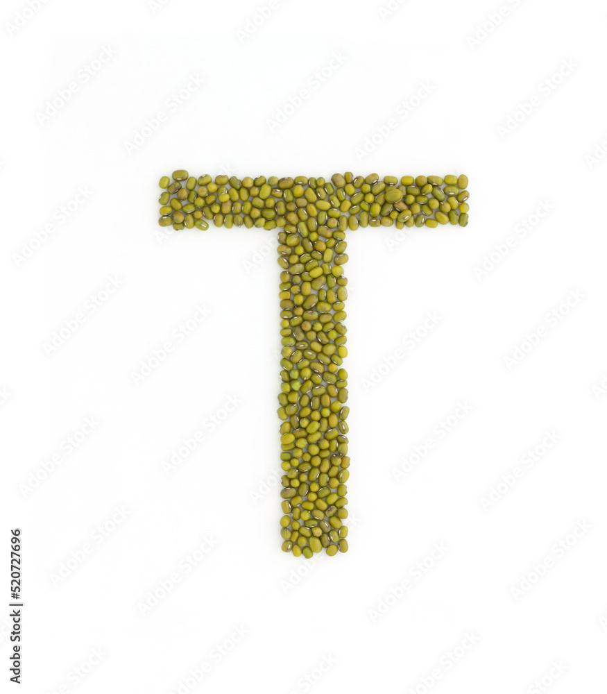 Capital letter T made from mung beans. Green mung bean font. Alphabet made from green gram . White background. Dry green maash seeds.