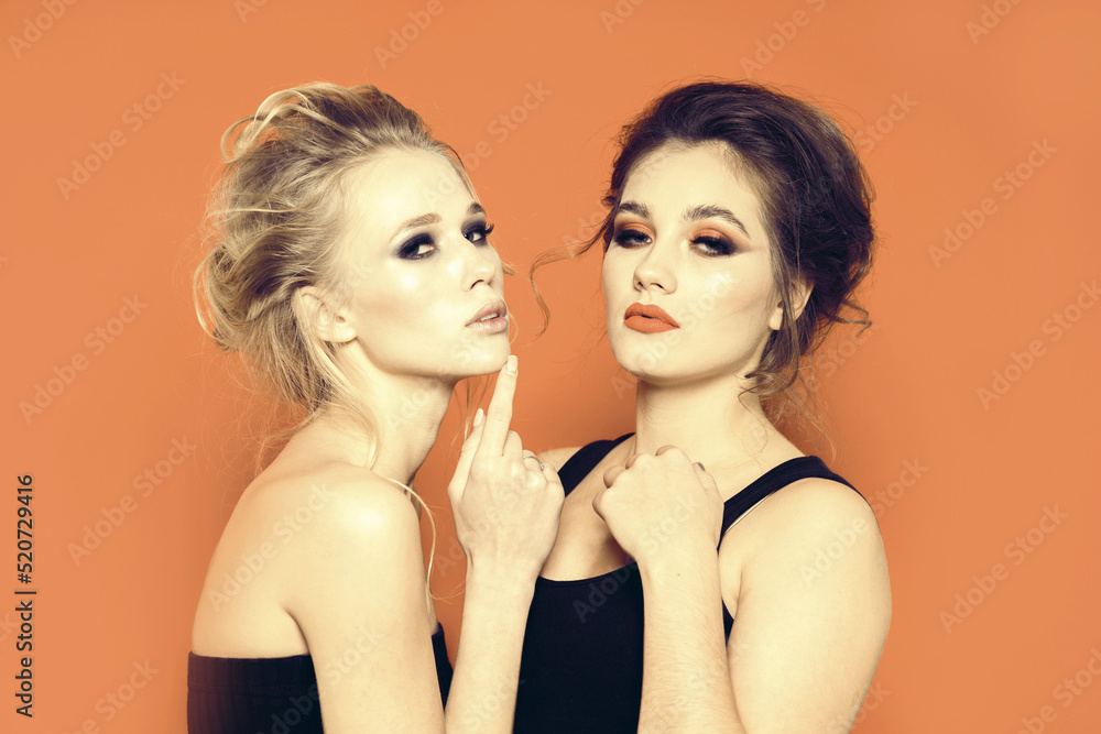 Two beautiful girls models in the studio on a bright background. Two beautiful girls models in the studio on a bright background.