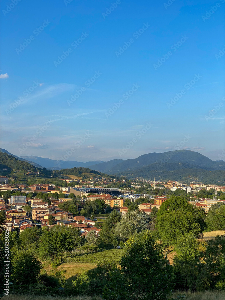 Cityscape with green mountains in the background, Italy