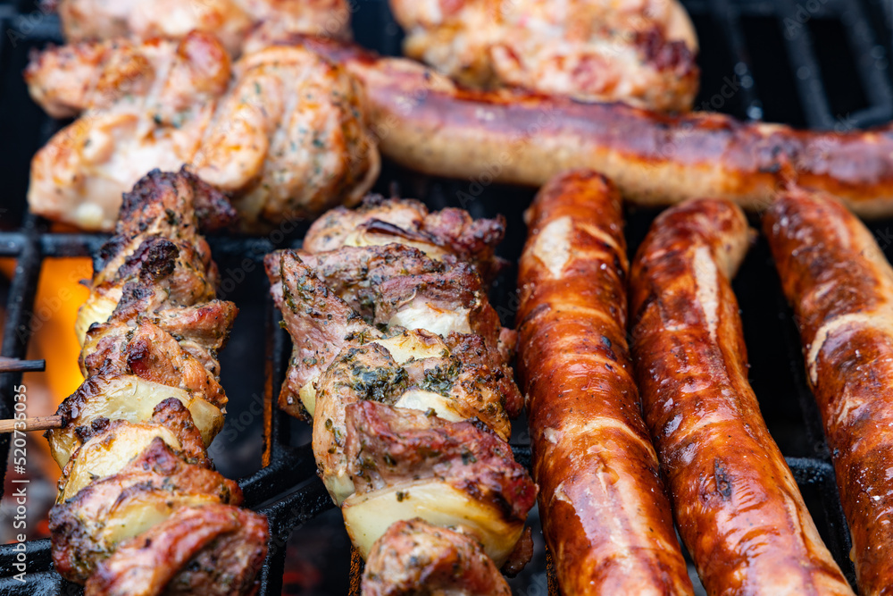 thuringian sausages and meat skewers on a charcoal grill thuringian sausages and meat skewers on a charcoal grill