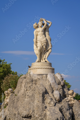 Landscape view of the fountain of the Three Graces, an elegant stone sculpture of women and angels on the famous landmark Place de la Comedie, Montpellier, France