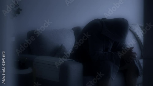 Evanescent scene of a depressed man in a bathrobe on the couch. Black and white. Static view