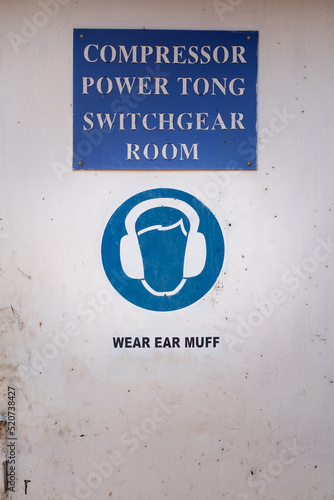 Caution sign to wear ear muff, the sound protective PPE which is showed on the door of engine switchgear room at the factory working place. Sign and symbol in industrial photo. photo