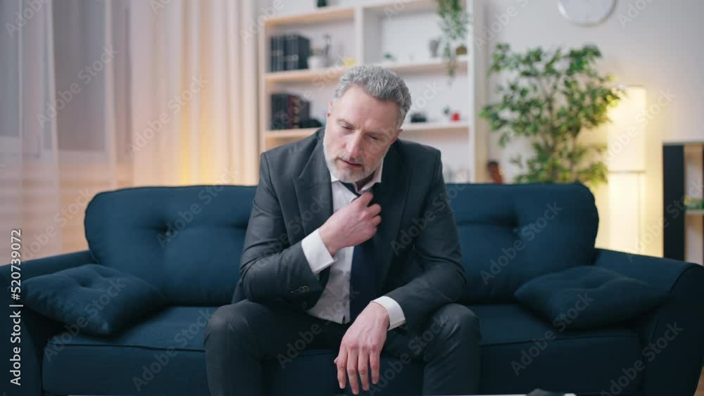Upset senior man loosening his tie, financial or work problems, bankruptcy Upset senior man loosening his tie, financial or work problems, bankruptcy