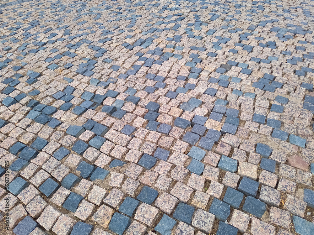 Old road pavement with granite stones. Paving stones. Old road pavement with granite stones. Paving stones.
