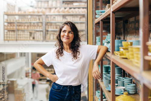 Cheerful ceramic store owner contemplating new creative ideas photo