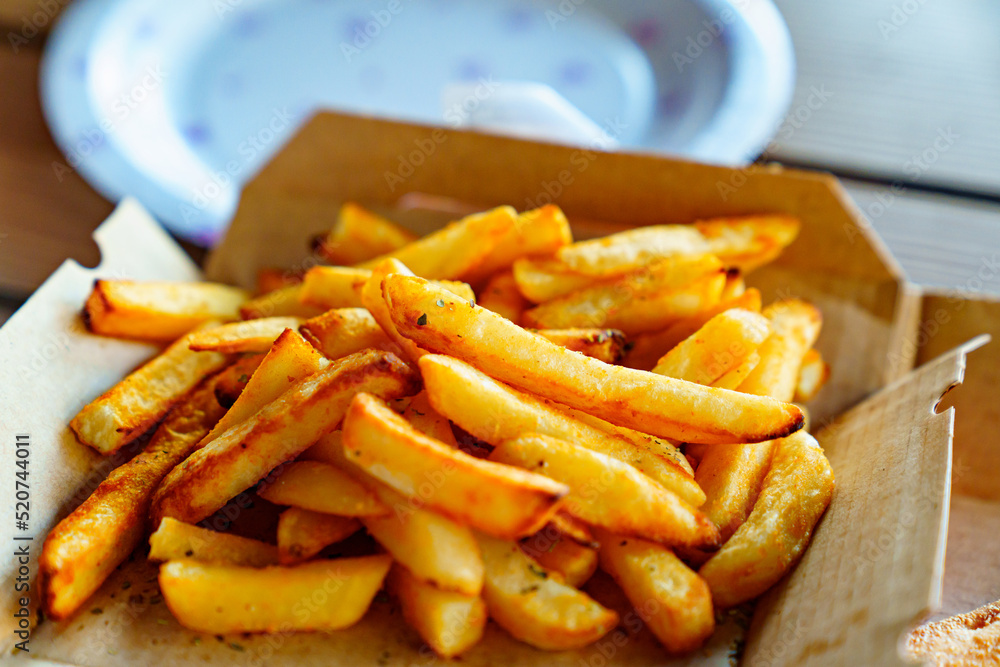 French fries on a cardboard box. fried potatoes. French fries on a cardboard box. fried potatoes.