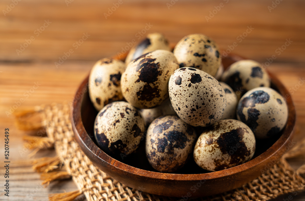 Many quail eggs placed against a wooden background. Many quail eggs placed against a wooden background.