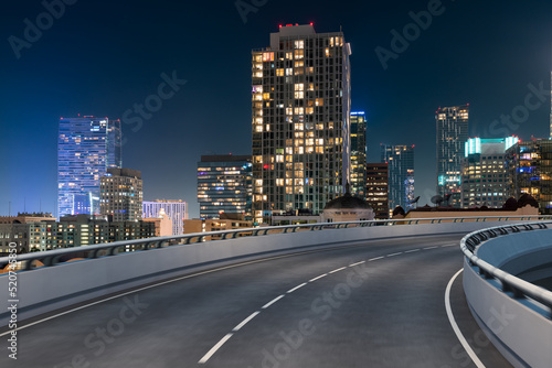 Empty urban asphalt road exterior with city buildings background. New modern highway concrete construction. Concept of way to success. Transportation logistic industry fast delivery. Los Angeles. USA.