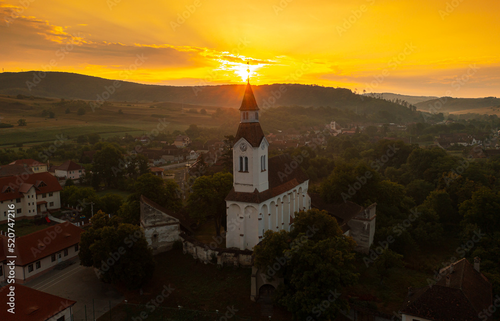 Aerial view with Bunesti fortified church from Transylvania, Romania, during a beautiful summer sunrise. Travel to landmarks of Romania.