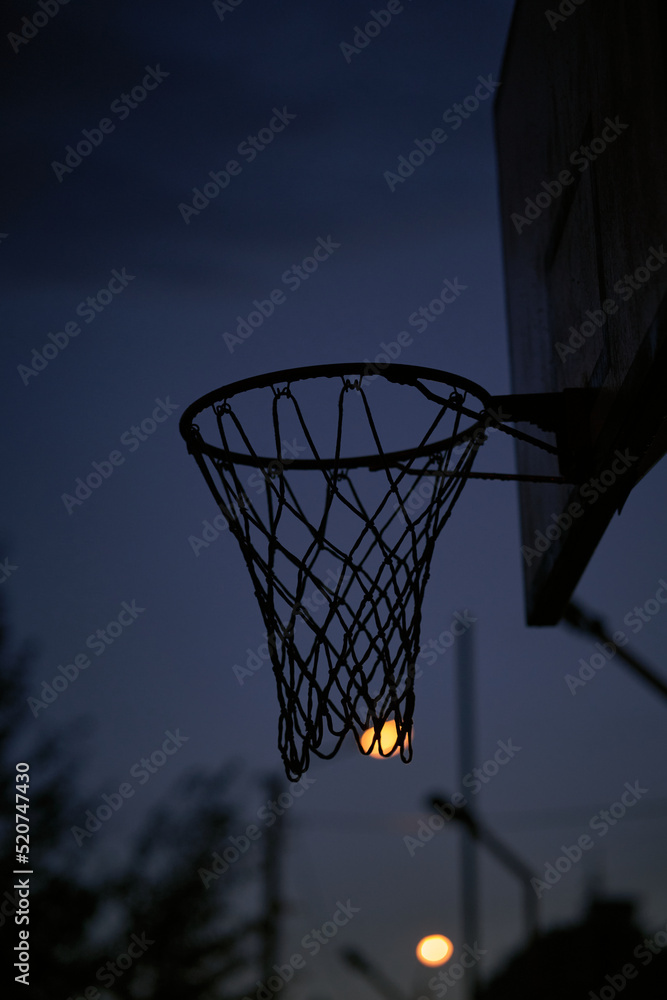 Basketball ring in the evening. Basketball net. Night basketball.