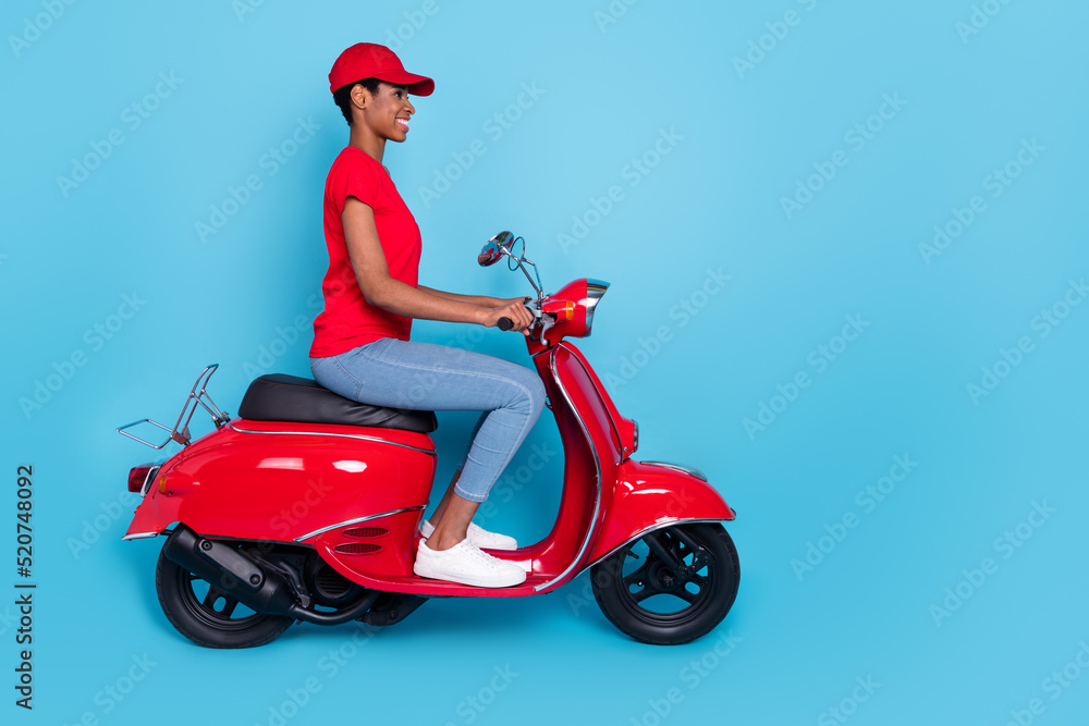 Photo of cute cheerful short hair person dressed red uniform moto rider looking empty space isolated blue color background Photo of cute cheerful short hair person dressed red uniform moto rider looking empty space isolated blue color background