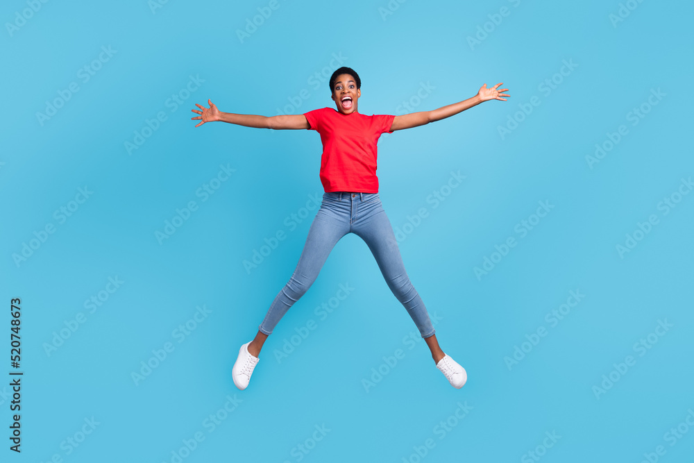 Photo of charming excited short hair person dressed red t-shirt jumping high like star isolated blue color background