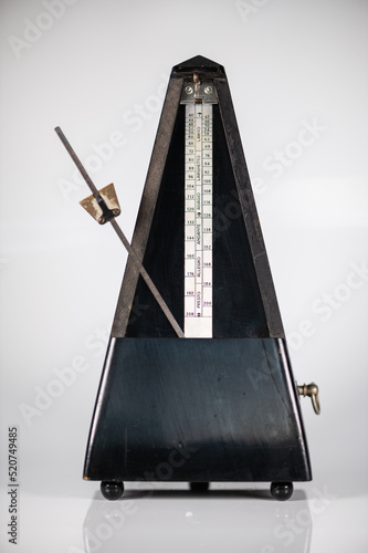 Old metronome with swinging clock