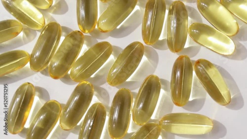 Yellow capsules medical pills rotating closeup. Vitamin C, Omega 3 in oil capsules. Pills and drugs. Pharmaceutical Industry. The medicine concept.