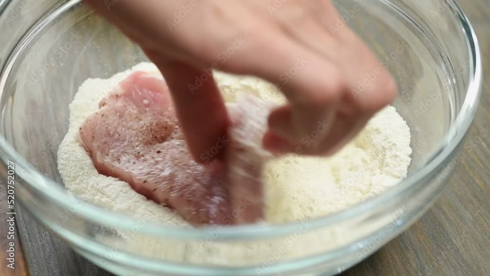The chef rolls the slice pork loin in flour.
The chef rolls the slice pork loin in flour.