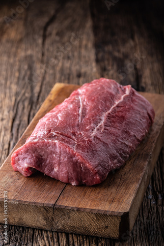 High rib eye steak whole on a wooden board.