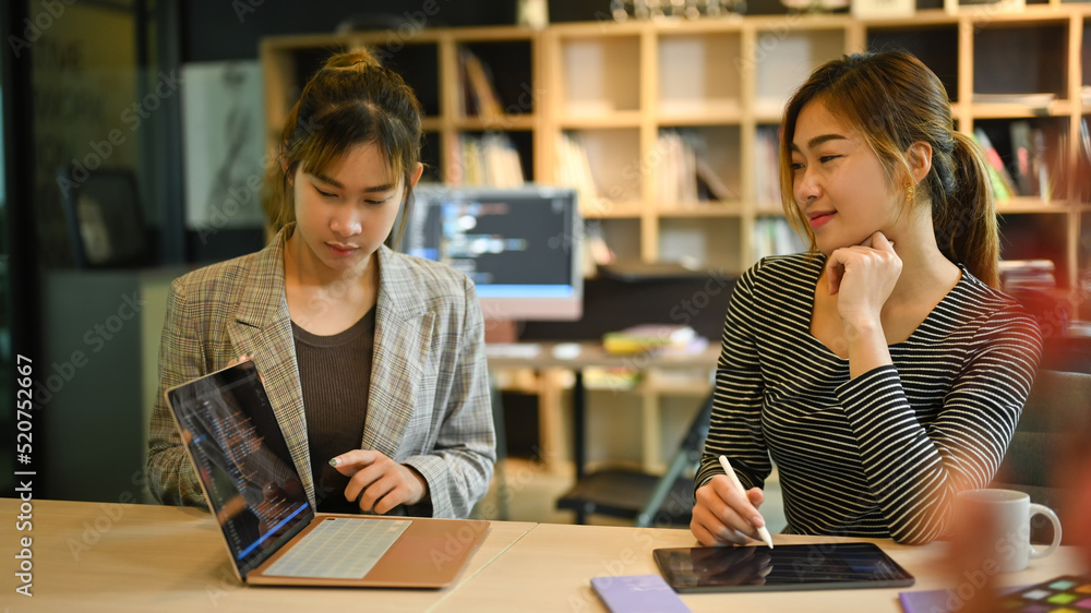 Two female IT developer working together for developing new software at corporate office Two female IT developer working together for developing new software at corporate office