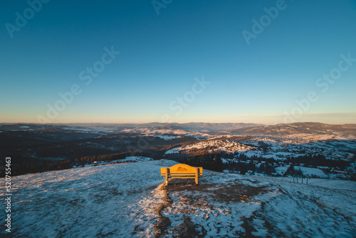 Bench on Mount Ochodzita in the Koniakow area of the Polish Beskydy Mountains illuminated in the morning light. Beautiful quiet resting place photo