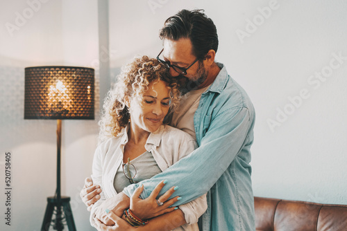 Romantic love and relationship with young couple hugging at home. Intimacy and romance with man and woman family. New home happiness concept emotion. People enjoying time together embracing tenderness