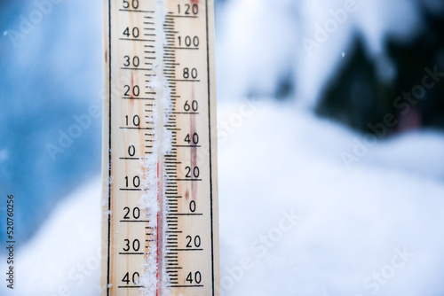 Winter time. thermometer on snow shows low temperatures in celsius or fahreneheit.