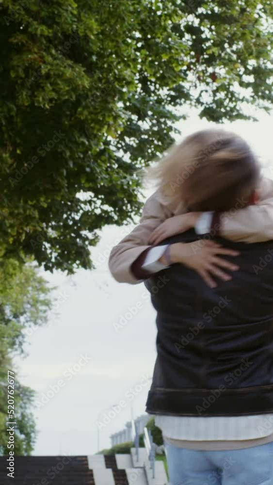 Young man meets young woman on date picking her up in his arms and spinning Young man meets young woman on date picking her up in his arms and spinning