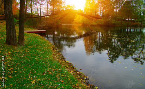 Autumn landscape with lake, green grass and colourful trees