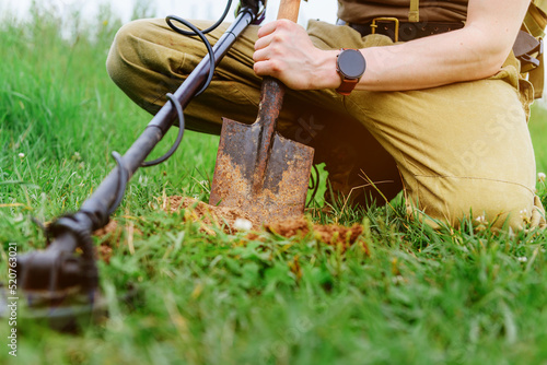 metal detector at work in the forest or field. Search for treasure and ancient values. Archeology. Man with a metal detector. Minesweeper Image. ?lose-up photo